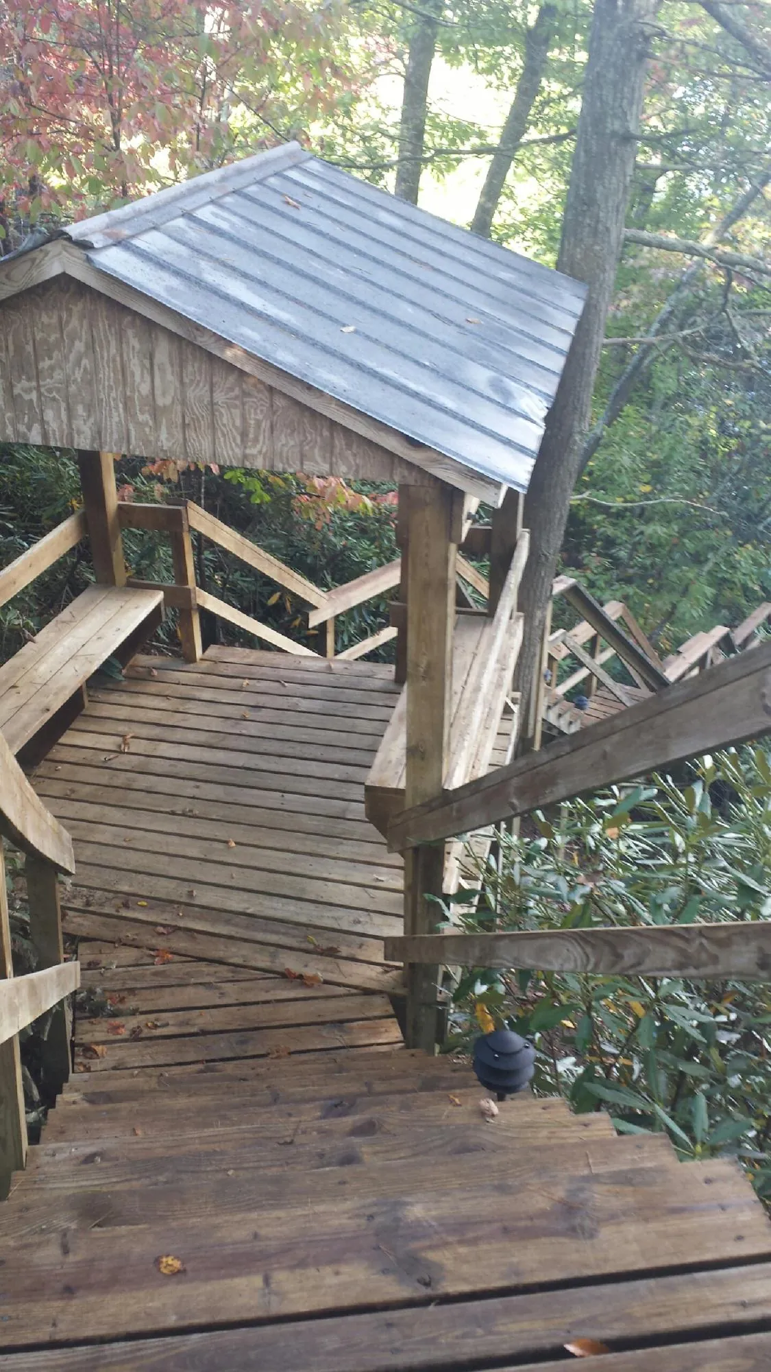 Metal roofed shelter over wooden steps on a wooded walkway — Skylight Repair & Installation work by our crew in American Falls