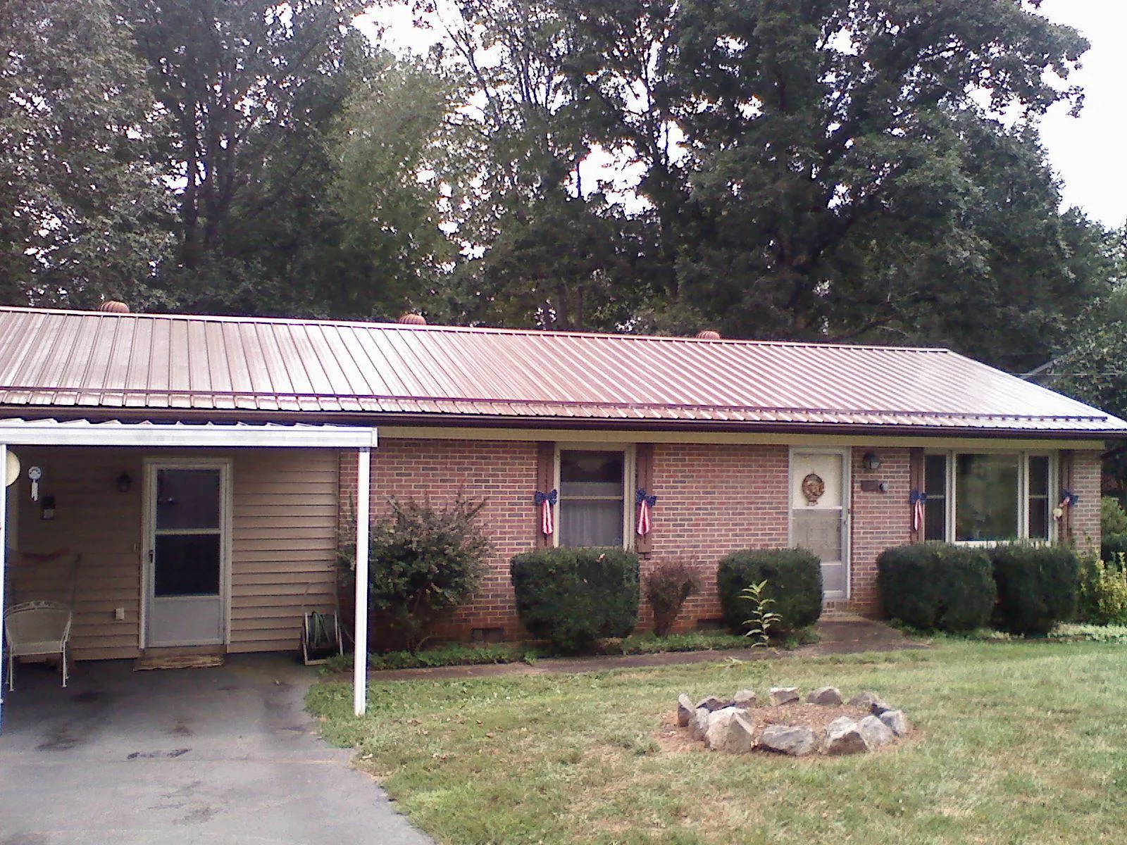 Bronze metal roof and carport on a brick ranch home — Roof Repair work by our crew in American Falls